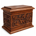 engraved wooden urn with intricate carvings on a white background