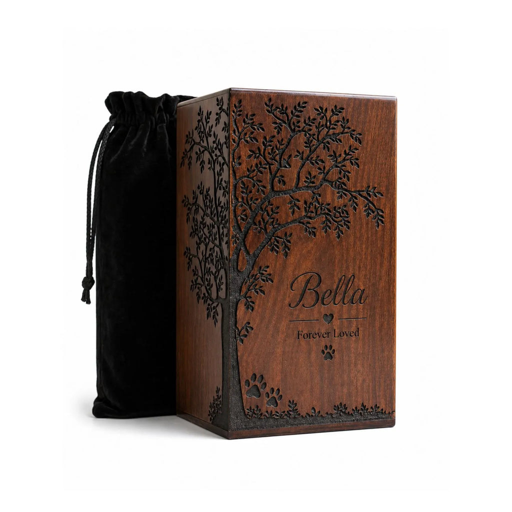 Handmade Wood urn for pet ashes with engraved tree design and 'Bella Forever Loved' text, accompanied by a black drawstring bag.