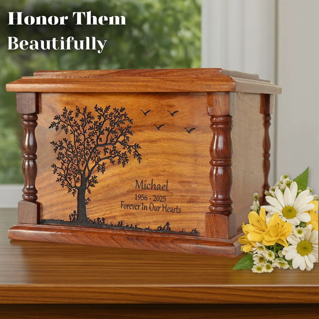Wooden urn with engraved tree design and text, accompanied by flowers on a wooden surface.