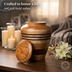 Wooden urn on a table with candles and flowers, with text 'Crafted to honor a life, not just hold ashes.'
