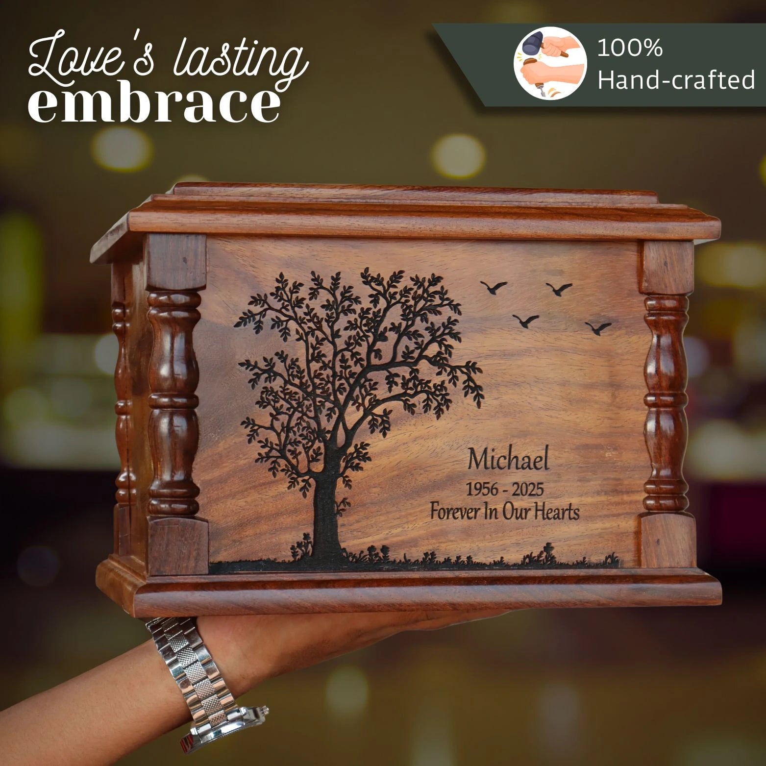 Wooden urn with engraved tree design and text, held by a hand.
