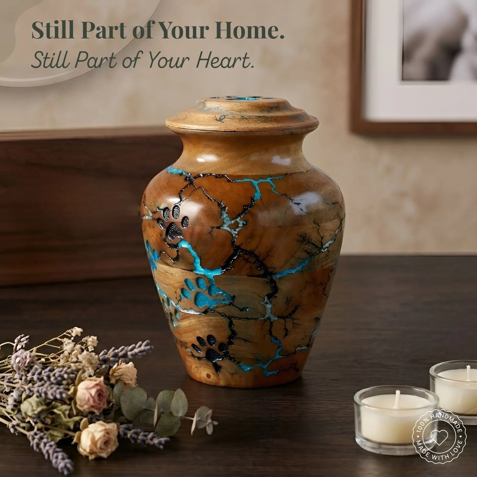 Decorative urn with paw prints on a wooden surface with candles and flowers.